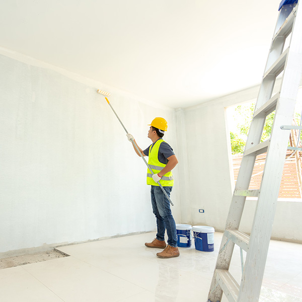 painter man at work with a paint roller on the wall